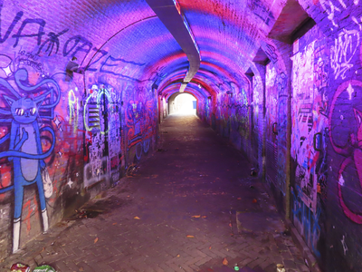 902068 Gezicht het wed aan de Oudegracht te Utrecht, van onderaf richting Ganzenmarkt. De tunnel vol graffiti wordt in ...